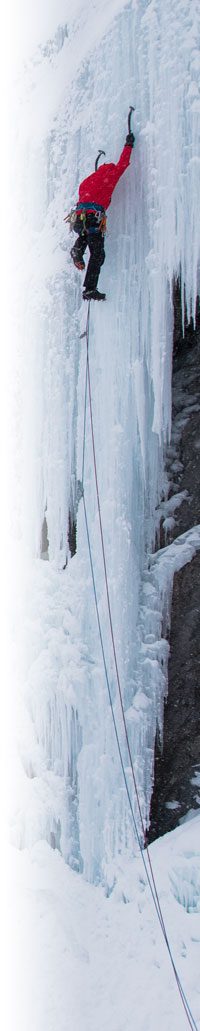 An ice climber going up an icicle on a cliff face.