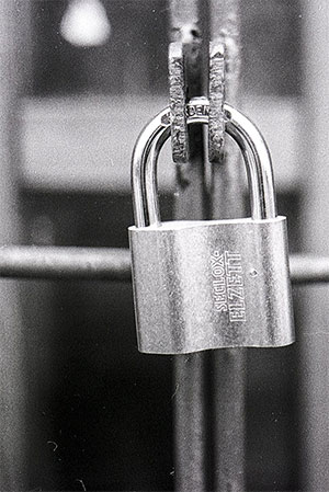 Padlock on a metal gate. Black and white.