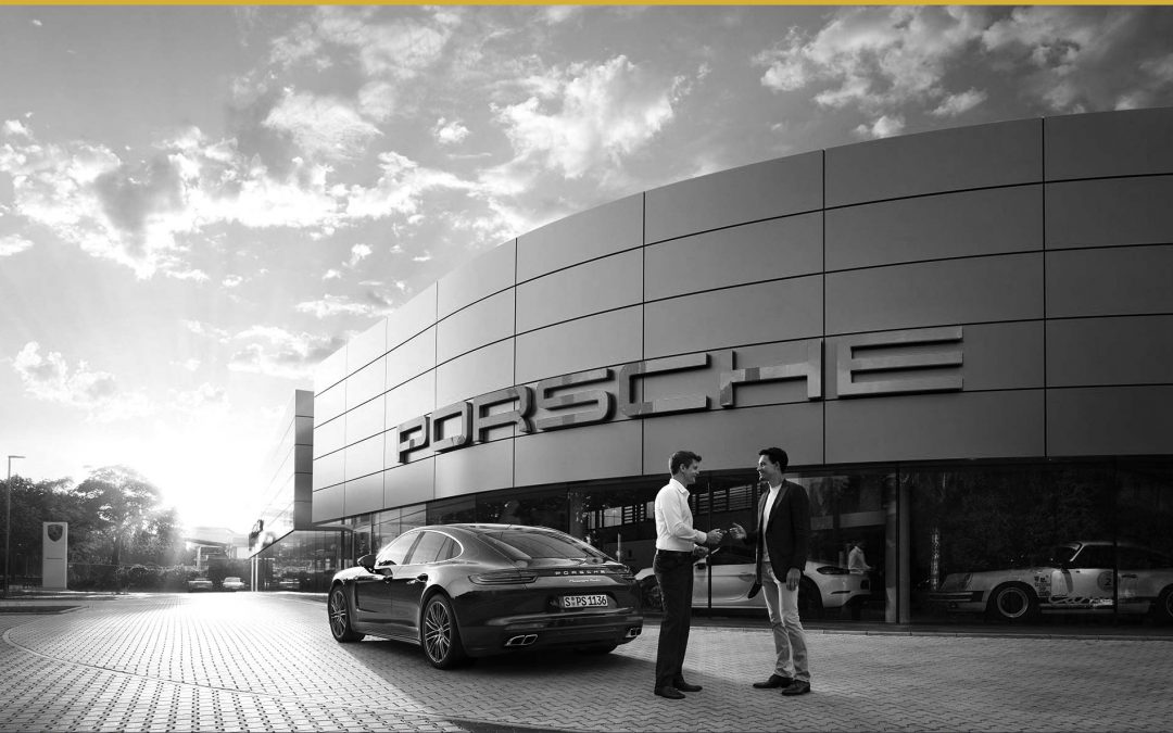 Man accepting ownership of a Porsche Panamera in front of a Porsche dealership. Power of Branding: Why It Works