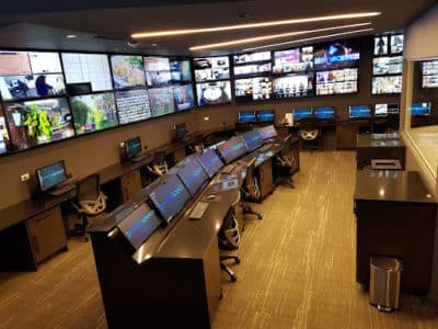 Control room at MediaScience Lab. Wood floor, arch desk with monitors, monitors on the wall.